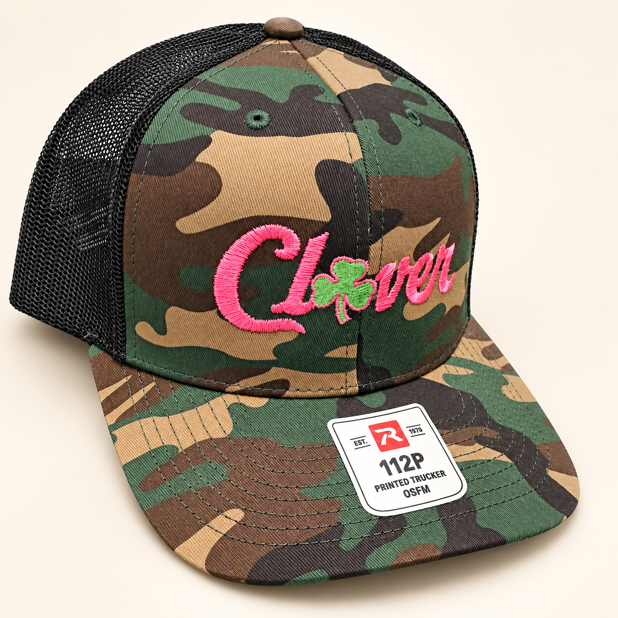Richardson 112P camo trucker hat with black mesh, pink Clover script with a small green clover