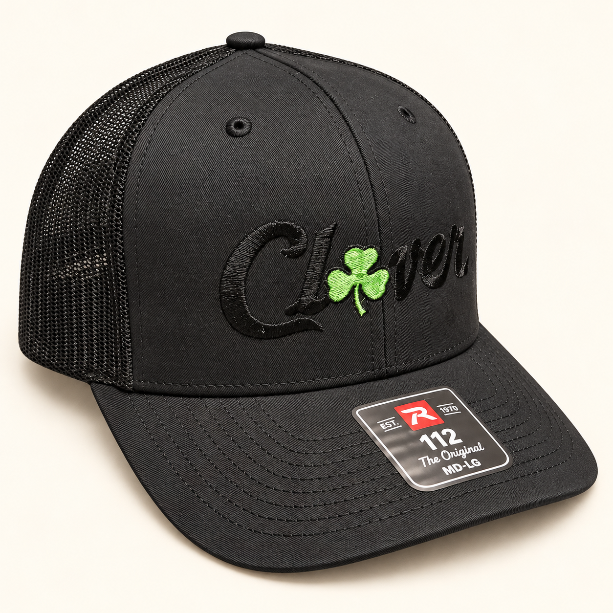 Black Richardson 112 trucker hat with black Clover lettering and a small green clover